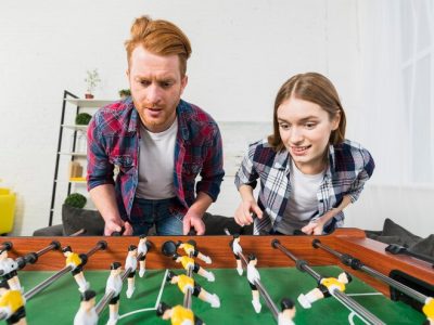 portrait-young-couple-enjoying-playing-soccer-game-home_23-2148048906